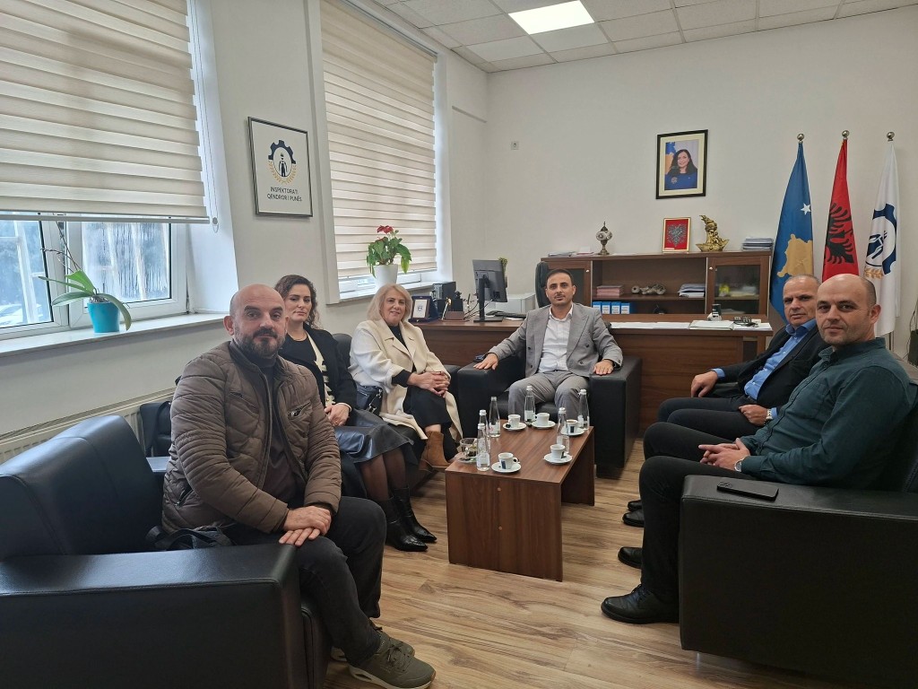 Takim formal në ambient zyre me flamuj.